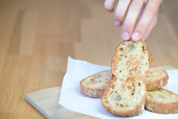 Hand takes piece of fried bread italian ciabatta