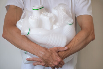 Close up of man with plastic bag with plastic bottles for recycling