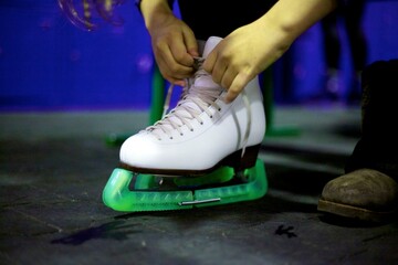 Girl tying shoelace on white skate shoe
