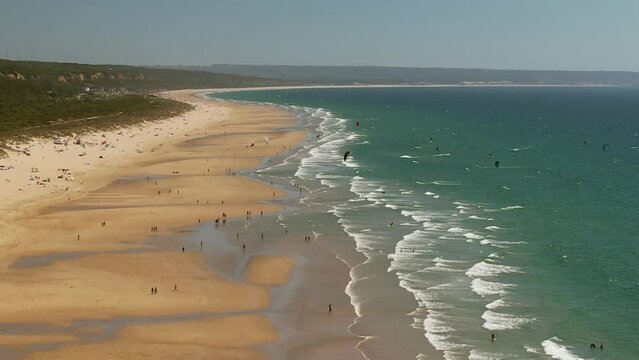 Aerial drone view of kytesufers at Caparica Beach in Almada District, Greater Lisbon, Portugal on a summer day