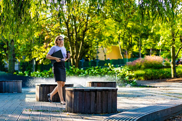 Fototapeta premium Coffee break - beautiful woman resting in city park 