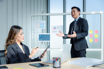 Businessman or manager with formal suit in presentation meeting or mentor with employee or colleague in modern office