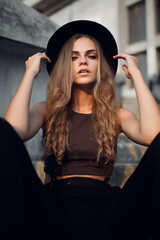 Outdoor portrait of a young beautiful fashion lady posing on the street of the old city. The model...