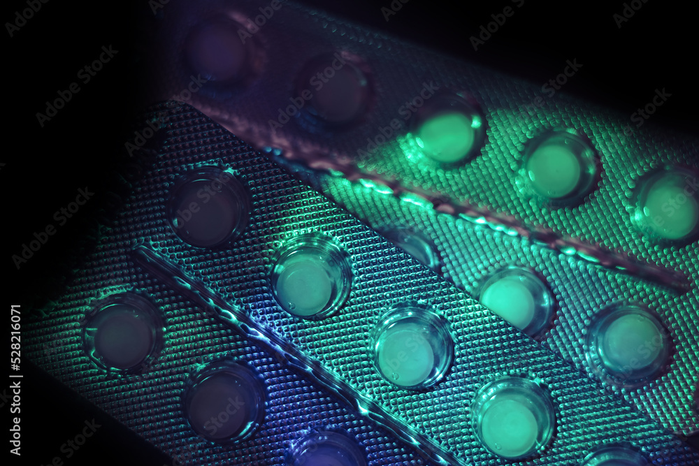 Poster pills or drugs in a package under neon light on a dark background pattern for design..