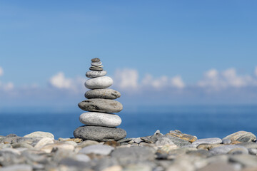 Pebble tower balance harmony stones arrangement on sea beach coastline