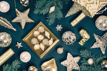 Fototapeta na wymiar Merry Christmas and Happy New Year rich golden and crystal baubles festive ornaments. stars glitter and Christmas tree branches with cones on teal green. Party decor banner. Top view full frame
