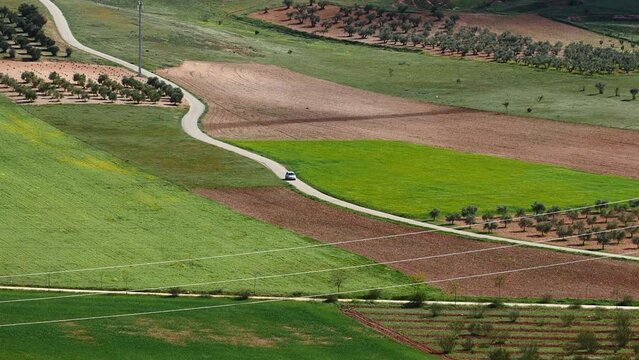 Un coche cruzando un camino rural entre campos de cultivo. Castilla la Mancha, Espa&ntilde;a.