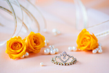 ティアラとオレンジ色のバラと真珠とリボンのデザイン（オレンジ色の背景）