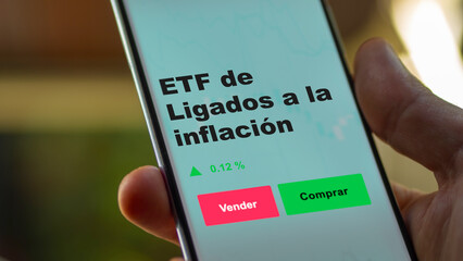 Un inversor está analizando el ligados a la inflación etf fondo en pantalla. Un teléfono muestra los precios del ETF para invertir.