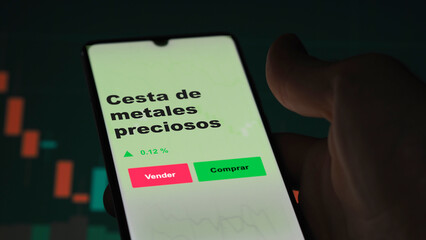 Un inversor está analizando el cesta metales preciosos etf fondo en pantalla. Un teléfono muestra...
