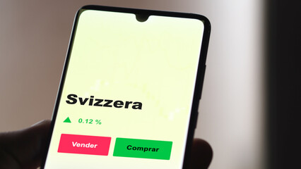 Un inversor está analizando el svizzera etf fondo en pantalla. Un teléfono muestra los precios del ETF SVIZZERA para invertir.