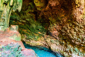 Fototapeta na wymiar Stalactites and stalagmites in a Kuza cave at Zanzibar, Tanzania. Natural pool with crystal clear water