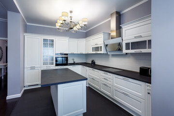 Fashionable kitchen with grey walls and white furniture, a kitchen in a modern classic style with granite countertop and bar island
