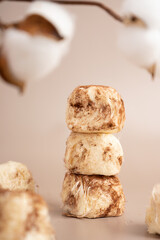 Creative concept sweet cotton candy pashmak stands in a pyramid on top of each other. Pastel beige background