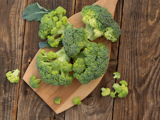 fresh green broccoli on a wooden cutting board with a knife. Broccoli cabbage leaves.