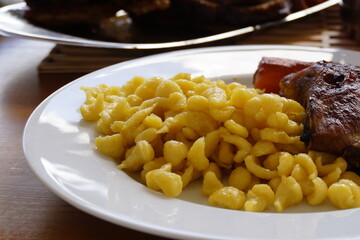 a delicious traditional Swabian meal of spaetzle or spaetzli with fried spareribs, Munich, Bavaria, Germany	