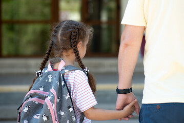 First day at school. Dad leads a little school girl in first grade. Back to school.