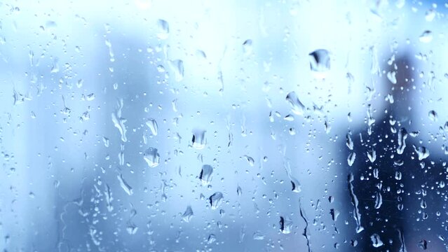 Personas desenfocadas pasean con paraguas bajo la lluvia.