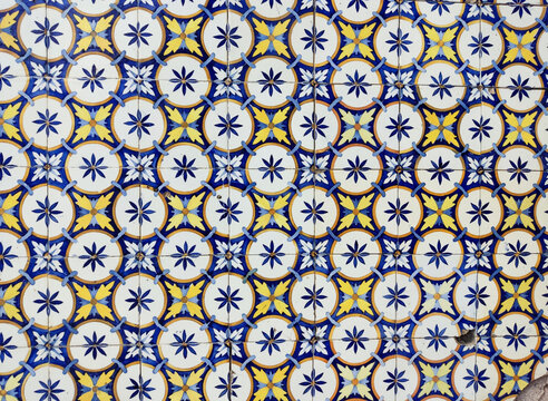 Ancient azulejo tiles on the wall of an old house in Portugal.