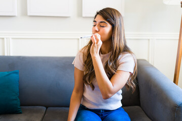 Young woman smoking cannabis to relax at home