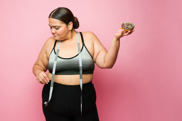 Happy fitness overweight woman on a diet eating junk food