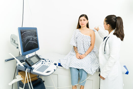 Young woman looking sick and in pain while getting a sonography test