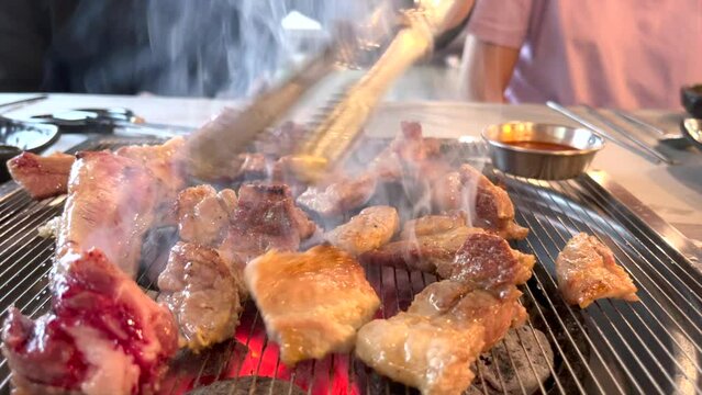 매우 비싼 한국의 돼지 생 갈비를 구워서 먹는 모습 숯불에 구워서 스모키한 향이 난다