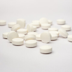 white round pills or tablets scattered on white background, medical drugs taken soft-focus with...