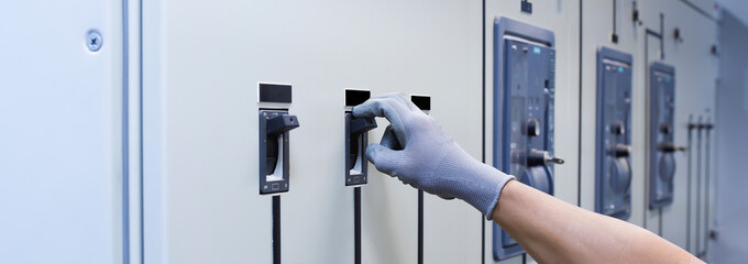 An electrical engineer is inspecting the operation of an electrical control cabinet. maintenance concept