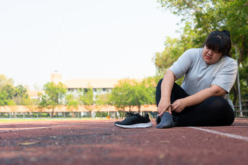 Asian overweight woman a new runner pain ankle during running, Athlete runner training accident....