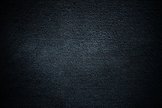 Photo of the texture of a black pile carpet in a car.Black soft background for text.