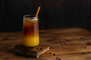Cold multilayered cocktail in a glass. Bumble coffee with ice. Conceptual bar, bar card. Copy space.