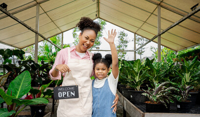 African American Single mom and her daughter in her green plant shop.Family Hands Together Teamwork Shop Small Business.green business for young activity help her mom.Smart woman concept,mother day.