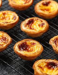 Traditional Portuguese custard tarts or Pastel de Nata freshly baked and cooling on rack