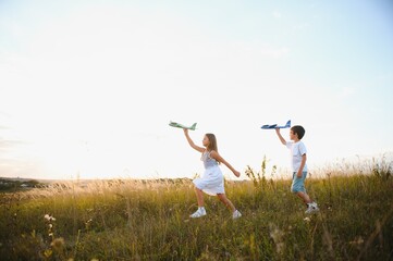 Active running kids with boy holding airplane toy.