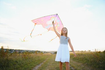 one happy little girl running on field with kite.