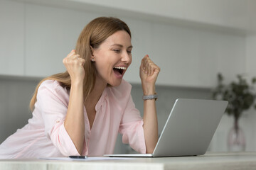 Happy laptop user woman celebrating good news, success, luck with winner yes hands, shouting for...