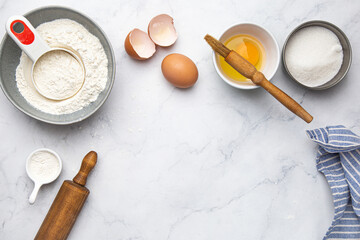 ingredients for cake (eggs, flour, sugar) on white marble table. Cooking and baking concept