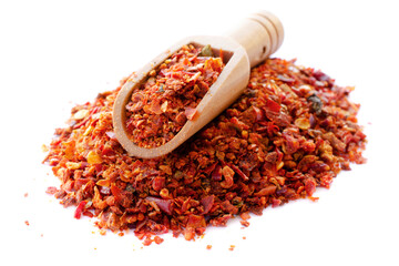 Red pepper with wooden spoon isolated on white background. Pile of crushed red peppers isolated on a white background. Pieces of red pepper with a wooden spoon isolated on a white background.