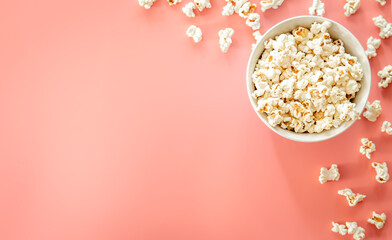 Popcorn plate on pink background, flat lay.