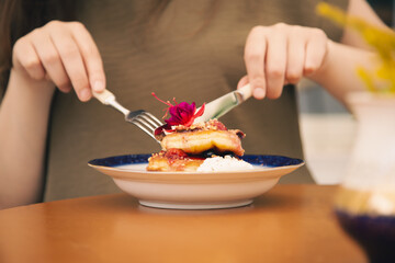 Appetizing pancakes decorated with berries and flowers.