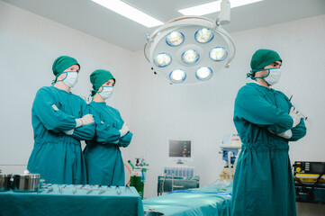 Team of male and female surgeon in srubs with surgical caps, gloves and face mask preparing for surgery in operation theatre in hospital