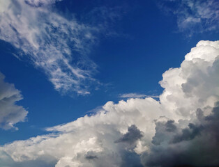 Naklejka na ściany i meble Bright deep blue sky with big white fluffy clouds. Glowing summer sky photo background.