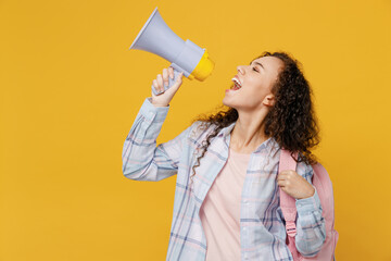 Young fun black teen girl student she in casual clothes backpack bag hold scream in megaphone discounts sale Hurry up isolated on plain yellow color background High school university college concept