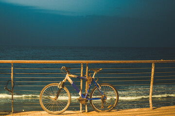 Dramatic photo of alone forgotten bike near the seaside chained and concept of loneliness
