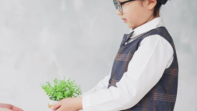 植物を手渡す少年と女性　環境保護イメージ