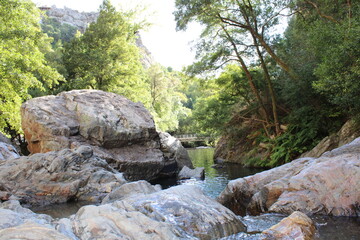 Naklejka na ściany i meble Stream with transparent water. Large Rocks surrounded by running water. Fragas de São Simão, river beach, Figueiró dos Vinhos Portugal