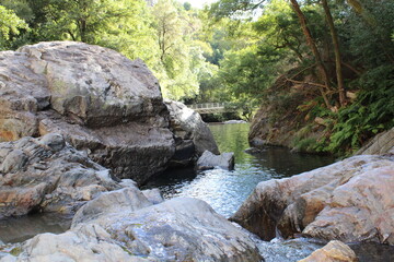 Naklejka na ściany i meble Stream with transparent water. Large Rocks surrounded by running water. Fragas de São Simão, river beach, Figueiró dos Vinhos Portugal