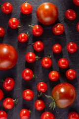 Heap of tomatoes at black slate background table