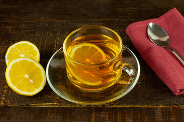 Cup of hot tea and lemon on rustic wooden table.